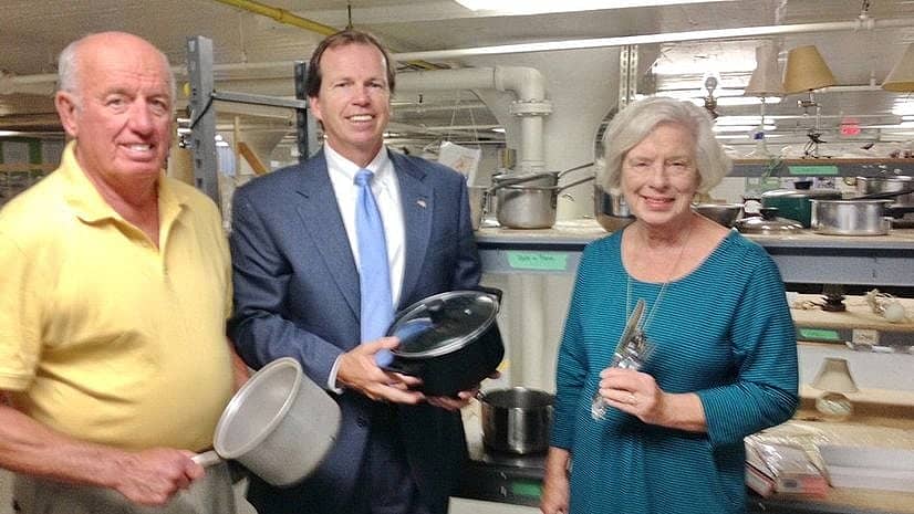Bill O'Donnell, another man and a woman stand and show off some donated pots and pans.